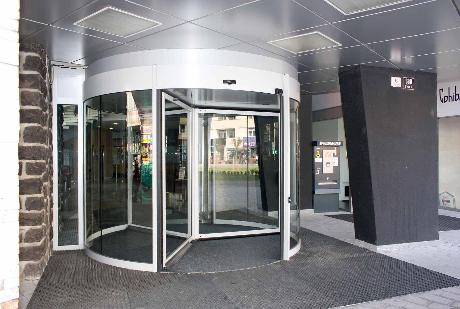 I přes nedostatek místa v okolí vstupního otvoru je možné použít karuselové dveře. Ty se dají zapustit jen zčásti – k budově jsou „přilepeny“ jedním otevřeným vstupem v tubusu.